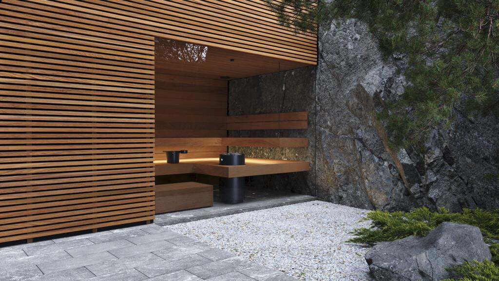 Modern sauna heater in a wood-clad sauna, set against exposed granite with a gravel entrance path.
