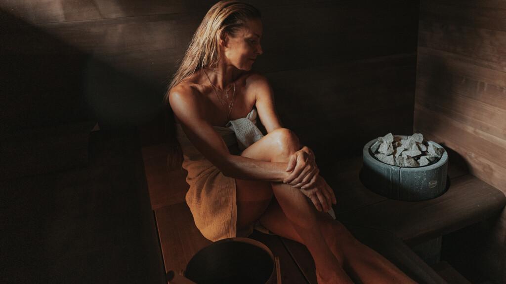 A woman enjoying Tulikivi sauna heater in a calm and quiet ambience